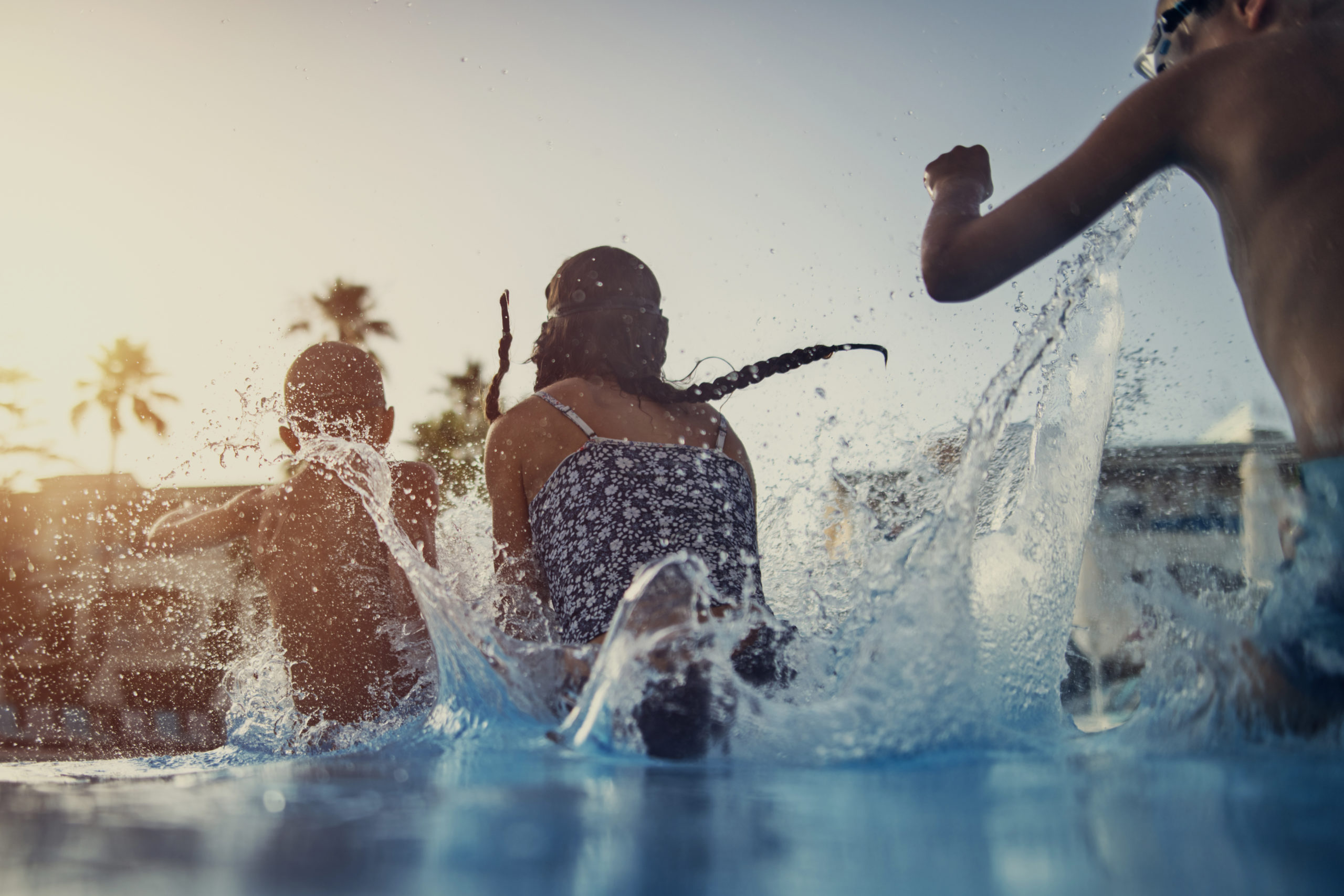 Kids jumping into the resort pool