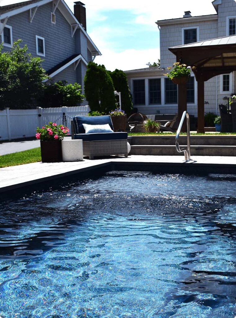 Comfortable backyard with gazebo, loungers and inground pool.