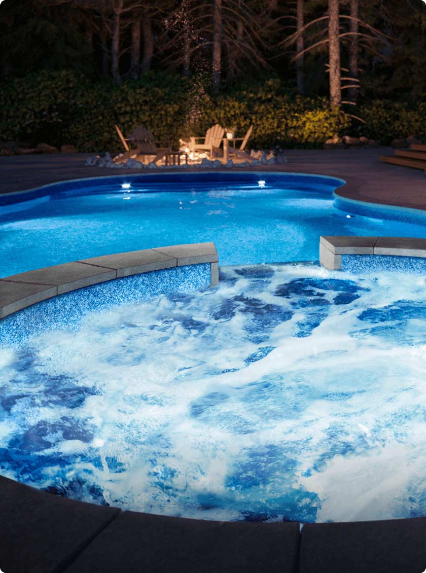 inground pool with spa at night with led lighting