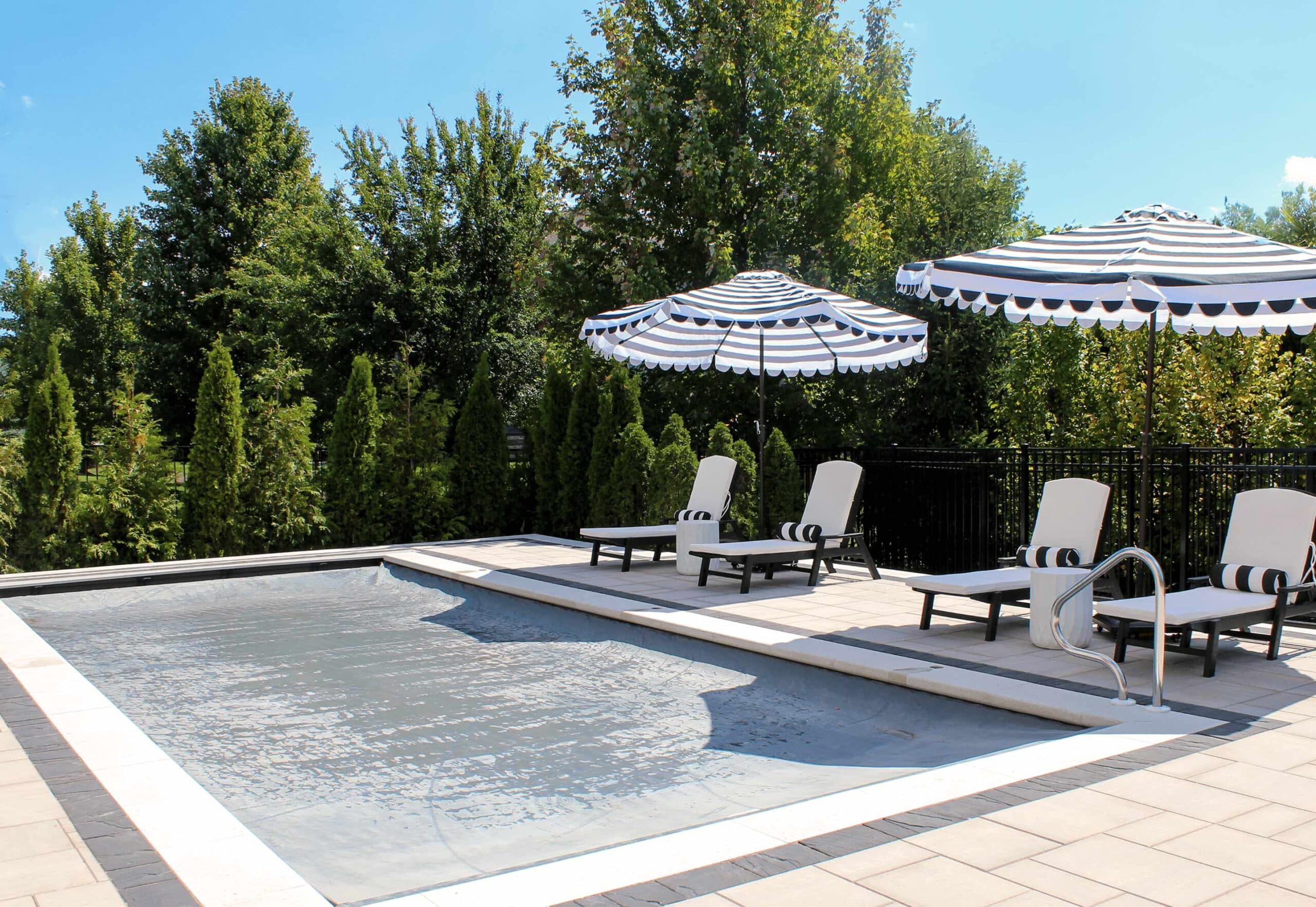 inground pool with grey automatic safety cover closed