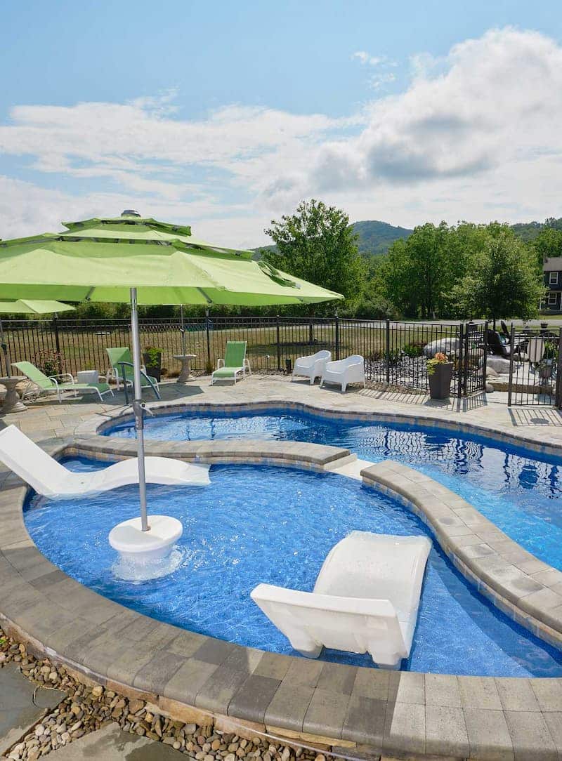 Fiberglass pool with mosaic tile design featuring a tanning ledge